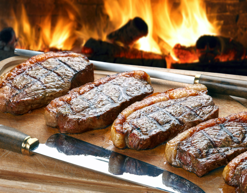 Alguns segredos podem influenciar para você conseguir realçar o sabor de uma carne para churrasco, como os temperos certos. Saiba como deixar a sua carne boa para churrasco. Como temperar carne para churrasco? O tempero para churrasco pode variar de acordo com o que você deseja atribuir para a carne, se deseja realçar o corte natural ou se prefere apostar em temperos. Ficou com dúvida sobre qual é a melhor carne para churrasco? Conheça as opções de melhores carnes para churrasco e veja dicas de como temperá-las: 1. Picanha A primeira da lista não poderia ser outra, a picanha é a queridinha da maioria dos amantes de churrasco, é apetitosa, suculenta e possui um sabor incomparável. Desse modo, uma peça de picanha pode ser temperada apenas com sal grosso ou com outros condimentos, tudo vai depender do seu gosto. A picanha combina com com manteiga temperada, que deixa a carne bem macia e um sabor inesquecível. Para isso, você vai precisar de: ½ tablete de manteiga em ponto de pomada; 4 dentes de alho picados; 1 fio generoso de azeite; Sal; Tomilho desidratado. Modo de preparo: Misture tudo em uma tigela, pincele sobre fatias grossas de picanha e leve para a churrasqueira. 2. Costela Essa é uma carne para churrasco que, seja de porco ou de boi, agrada muita gente e sempre ganha destaque nos churrascos. A costela tem fibras grossas e compridas, sendo assim, seu cozimento é mais lento. Por si só, essa carne já é bem saborosa, mas sempre tem como realçar. Para isso, você pode espalhar sal grosso em todas as partes da carne e deixar descansar por 10 minutos antes de levar para a churrasqueira. Depois, embrulhe em um papel alumínio e, se for de sua preferência, acrescente outros temperos como ervas finas, alho, pimenta, entre outros. Feche todos os lados do papel e asse até dar o ponto. 3. Alcatra Apesar de não conter tanta gordura, a alcatra é uma carne para churrasco que tem muito sabor e combina com molhos especiais, como por exemplo o molho de alho. Seu segredo é colocá-la na churrasqueira apenas com sal grosso e deixar assar até criar uma crosta dourada, depois que chegar neste ponto, coloque o molho e leve novamente para a churrasqueira até dar o ponto final. Para o preparo do molho você vai precisar misturar apenas 3 ingredientes: 4 dentes de alho picados; 1 xícara de óleo; 1 pitada de sal. 4. Fraldinha Assim como a alcatra, a fraldinha é uma carne que tem pouca gordura, além de ser uma carne de corte pequeno e fibras longas. Com isso, o ideal é cortar a peça em pedaços mais grossos e fazer o seu preparo em uma grelha. Curiosidade que poucos sabem, é que a fraldinha possui pouca concentração de gordura, sendo conhecida como uma opção leve e macia. Para acentuar o seu sabor e garantir um resultado suculento, você pode combinar: Sal fino a gosto; Mostarda escura; Molho shoyu. Modo de preparo: Passe a mistura antes de levar para a brasa. Enquanto dourar, pincele a carne com azeite. 5. Contrafilé O contrafilé, que também pode ser encontrado como lombo desossado ou filé curto, é um dos cortes mais versáteis, permitindo muitos tipos de temperos para churrasco. Aqui, o segredo é a maneira de como deve ser assado ou grelhado. O foco é prepará-lo em uma temperatura alta para evitar que a carne fique dura. Para o tempero da carne, uma sugestão que você pode apostar é preparar uma manteiga temperada com alho e ervas frescas. Veja os ingredientes: ½ tablete de manteiga em ponto de pomada; 2 dentes de alho picados; 1 fio generoso de óleo; Salsa, cebolinha e manjericão picados; Sal; Pimenta-do-reino. Modo de preparo: Pincele a carne, coloque na churrasqueira e sirva o corte mal passado ou ao ponto. Como amaciar carne para churrasco? A carne vermelha é uma das preferidas dos brasileiros, além do churrasco, pode ser preparada de diferentes maneiras. Uma carne de churrasco bem feita deixa qualquer um com água na boca, principalmente, quando está super macia e suculenta, porém, nem todas as carnes tem a maciez em sua natureza. Normalmente, as mais macias têm um preço um pouco mais alto por serem cortes nobres do boi. Mas não se preocupe, não é por esse motivo que você vai cancelar o churrasco com a família e amigos. Separamos algumas dicas para te ajudar a ter uma carne macia para churrasco: Marinada Marinar a carne é sempre uma maneira eficaz de amaciar a sua carne. Um grande aliado do amaciamento de carnes para churrasco é a mistura de azeite e vinagre, você só precisa misturar os dois ingredientes e deixar a carne marinando, ou seja, descansando por pelo menos 2 horas antes de levar para a churrasqueira. Essa dica, além de amaciar, também deixa a carne de boi para churrasco com um ótimo tempero. Uma outra dica de ingrediente para amaciar a carne é a cerveja, uma ótima opção para quem já ama tomar uma cervejinha acompanhado das carnes no churrasco. Você só precisa deixar a carne descansar por algumas horas antes de prepará-la. É recomendado usar uma lata para cada quilo de carne. Como cortar carne para churrasco? A maneira certa de cortar a carne faz toda a diferença na hora de servir o seu churrasco. Mesmo escolhendo a melhor carne e temperando da maneira correta, nada adianta caso o corte não favoreça essa qualidade. Quando cortada errada, a carne pode ficar dura. Há quem acredite que o corte da carne deve seguir o caminho das linhas formadas pelas fibras. No entanto, o que recomendamos é o corte no sentido contrário. Mantenha a lâmina da faca em um ângulo de 90 graus em relação às fibras da carne. Por isso, é importante que você identifique a posição das fibras na carne crua, pois vão variar de acordo com cada peça. Algumas vantagens em cortar dessa maneira são: Facilita a mastigação; É esse processo de quebra das fibras que torna o aspecto da carne mais macio; Facilita a entrada dos temperos; Torna o assamento mais ágil; Perde menos líquido e, assim, fica mais suculenta; Essa dica da fibra vale para o corte antes e depois do preparo na churrasqueira. Como calcular carne para churrasco? Nada como ir ao um churrasco e ter carne suficiente para todos, por isso, aprenda como calcular carne para churrasco: 1- Tempo de duração do churrasco Definir o tempo de duração do churrasco é um fator importante para calcular a quantidade de carnes e acompanhamentos que serão necessários para atender a todos os convidados. 2- Tipos de carne para churrasco A escolha dos cortes é outro ponto importante para determinar a quantidade de carne necessária para o churrasco. Na hora de planejar, a dica é pensar em opções para a entrada, prato principal e também aperitivos. 3- Quantidade de carne necessária Depois de definir o tempo de duração e os tipos de cortes, você tem em mãos todas as informações para calcular a quantidade de carne necessária. Com relação à proporção, é interessante pensar de 350 a 400 gramas de carne por pessoa, somando todas as carnes. São de 50 a 60 gramas para as entradas, 200 gramas para as carnes principais e mais 50 a 60 gramas para os petiscos. Lembrando que quanto mais opções, maior é a quantidade necessária. Ao seguir todas essas dicas e seguir o passo a passo para a quantidade ideal de carne para churrasco, você estará pronto para confirmar a presença dos seus convidados!